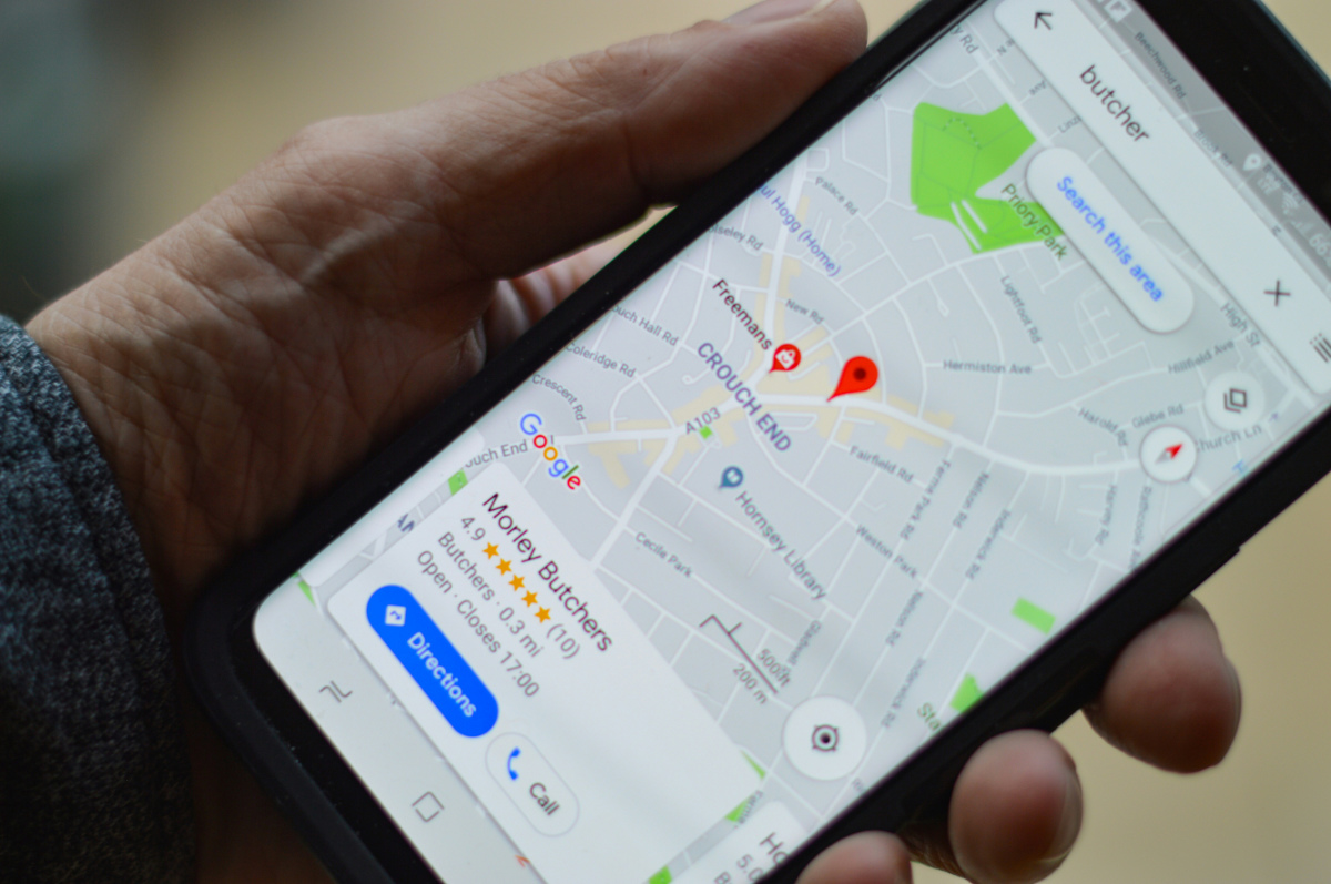 hand holding phone looking for local business to highlight services offered for local seo